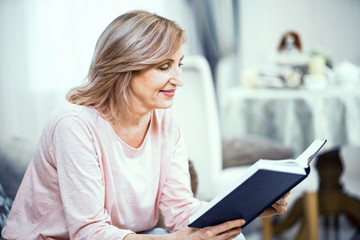 Beautiful mature woman is reading a book