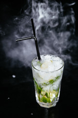 Mojito cocktail on black smokey background.