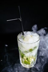 Mojito cocktail on black smokey background.