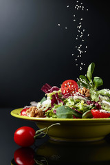Green salad with cherry tomatoes,  sesame, walnuts and vegetable oil.