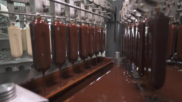 ice cream production, chocolate coating process on ice cream, production line, dairy products.