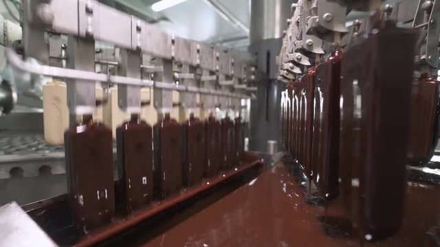 ice cream production, chocolate coating process on ice cream, production line, dairy products.