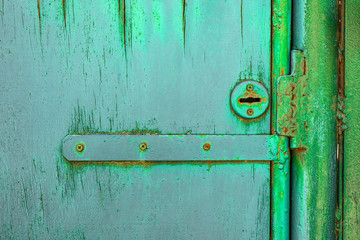 Key hole and latch on wood green door with cracked and scratch. Horizontal grunge texture