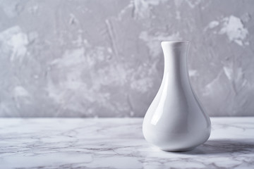 White vase isolated on plaster grey wall background, copy space. Home decor
