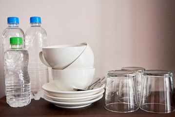 Tea and coffee making set in luxury hotel room with clean cups, glasses and bottles of water, copy space. Hotel basic accommodation