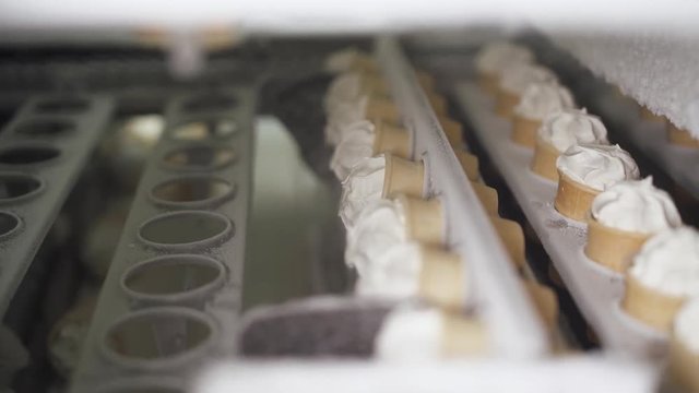 ice cream production, transportation waffle-cone with plombir ice cream on production line, dairy products.