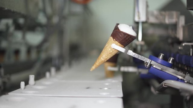 ice cream production, transportation waffle-cone with plombir ice cream on production line, dairy products.