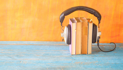 audio book concept, with stack of books, headphones, panorama, good copy space