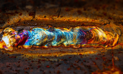 Welding close up showing heat coloring, tempering of the steel - obrazy, fototapety, plakaty