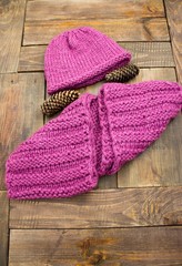 Fototapeta na wymiar Warm, winter, knitted hat and handmade scarf on brown background.
