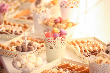 Delicious cnady bar with colored macaroons, cupcakes and other sweets