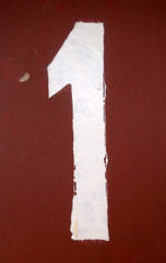 Number 1 in stencil on metal wall.