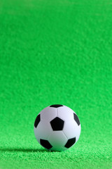 Small soccer ball on a green artificial football field. Football concept.