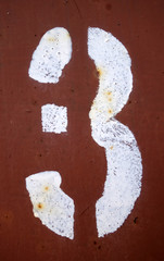Number 3 in stencil on red metal wall.