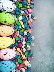 Colorful Easter Egg, sweet candies background. Top view with copy space