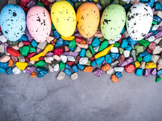 Colorful Easter Egg, sweet candies background. Top view with copy space