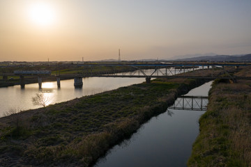 夕暮れの渡良瀬川とローカル列車