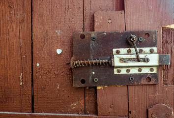 Fototapeta premium Rusty old secret lock on red wood door with cracked and scratch. Horizontal grunge texture