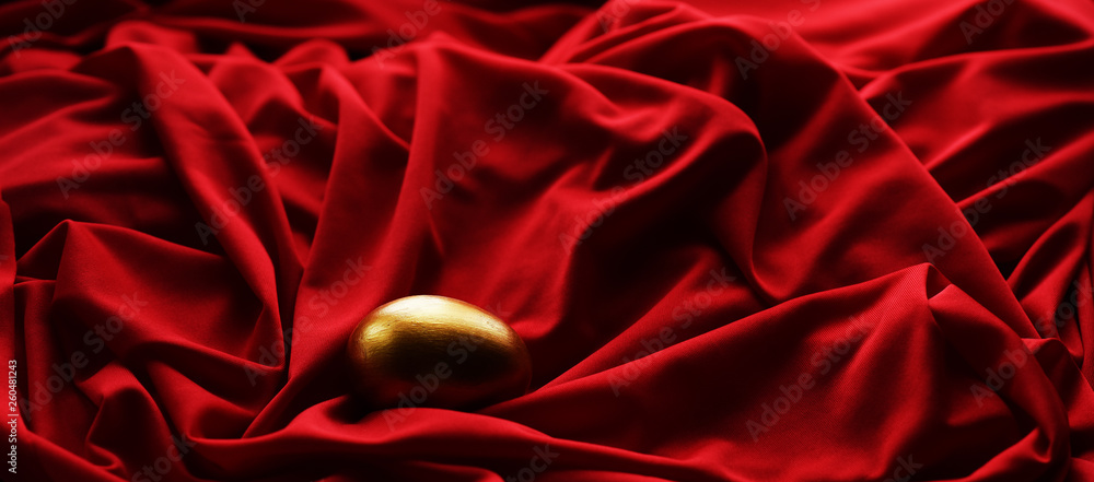 Wall mural Easter egg hand painted gold on a red background