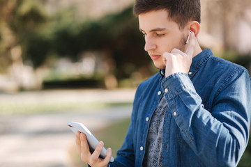 Handsome man use phone and wireless headphones for video chatting. Video call