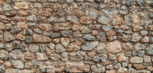 Texture of old stone wall. Surface from grey and orange rocks. Ancient wall in Macedonia