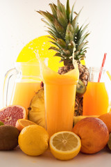 Fresh juice dynamic splash. A glass of fruit drink and fruits on a white background. Delicious, tasty, sweet summer set. 