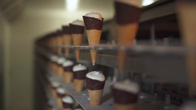 ice cream production, transportation waffle-cone with plombir ice cream on production line, dairy products.