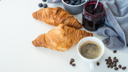 Croissant z owocami i kawą leżące na białym tle
