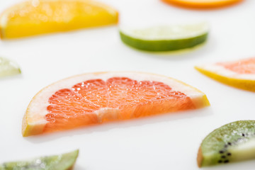 Juicy fresh sliced citrus fruits on white surface