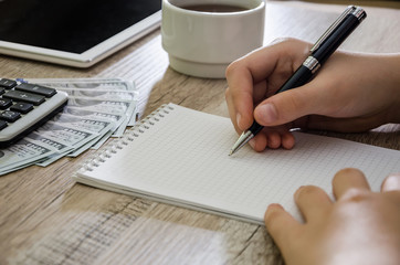 female hand writing something on a pad