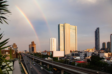 skyscrapers and BTS in Bangkok against rainbow sky
