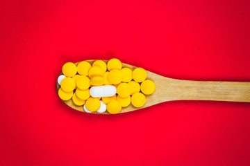 Fototapeta na wymiar pharmaceutical medicine pills, tablets and capsules on wooden spoon