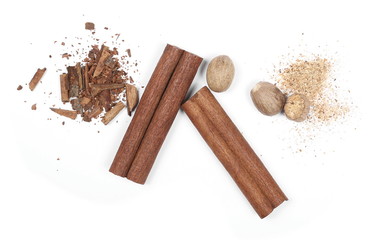 Cinnamon sticks, shavings and nutmegs isolated on white background, top view
