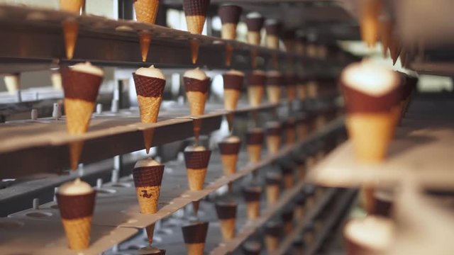 ice cream production, transportation waffle-cone with plombir ice cream on production line, dairy products.