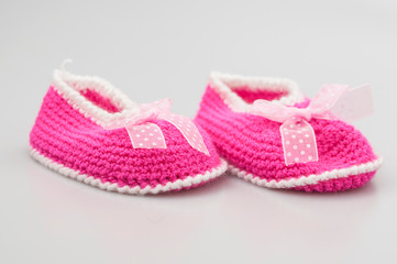 Baby girl shoes on white background, banner, copy space. Knitted baby booties.