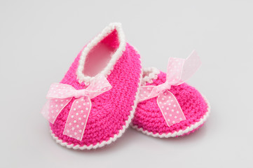 Baby girl shoes on white background, banner, copy space. Knitted baby booties.