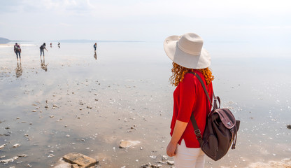 Woman wearing red shirt and white hat watching Salt Lake (Turkish: Tuz Golu) is the second largest lake in Turkey.