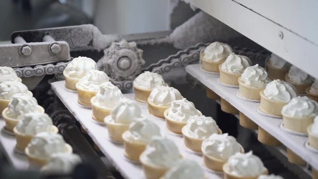 ice cream production, transportation waffle-cone with plombir ice cream on production line, dairy products.