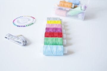 spools of colorful thread and meter on white background