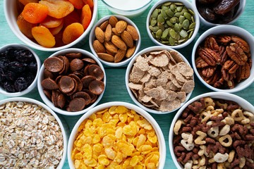 various cereals, nuts and dried fruits on wooden surface