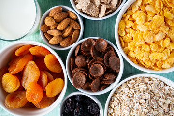 various cereals, nuts and dried fruits on wooden surface