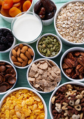 various cereals, nuts and dried fruits on wooden surface