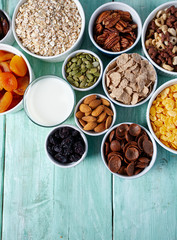 various cereals, nuts and dried fruits on wooden surface