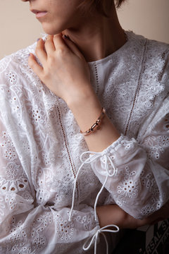 Asian chinese model wearing a rose gold bracelet and white lace dress, presenting the bracelet product