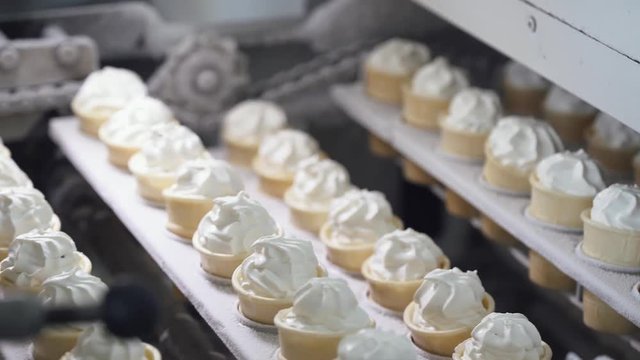 ice cream production, transportation waffle-cone with plombir ice cream on production line, dairy products.