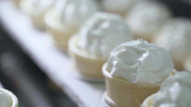 ice cream production, transportation waffle-cone with plombir ice cream on production line, dairy products.