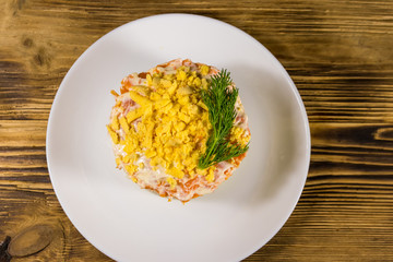 Traditional russian salad Mimosa on wooden table