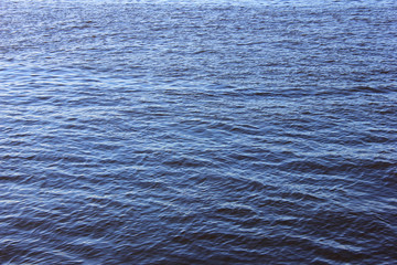Calm blue water surface. River or sea water smooth background with small waves
