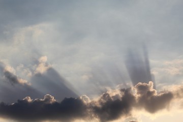 Fototapeta na wymiar raios solares entre nuvens no céu azul