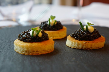 black caviar on a canape with soured cream